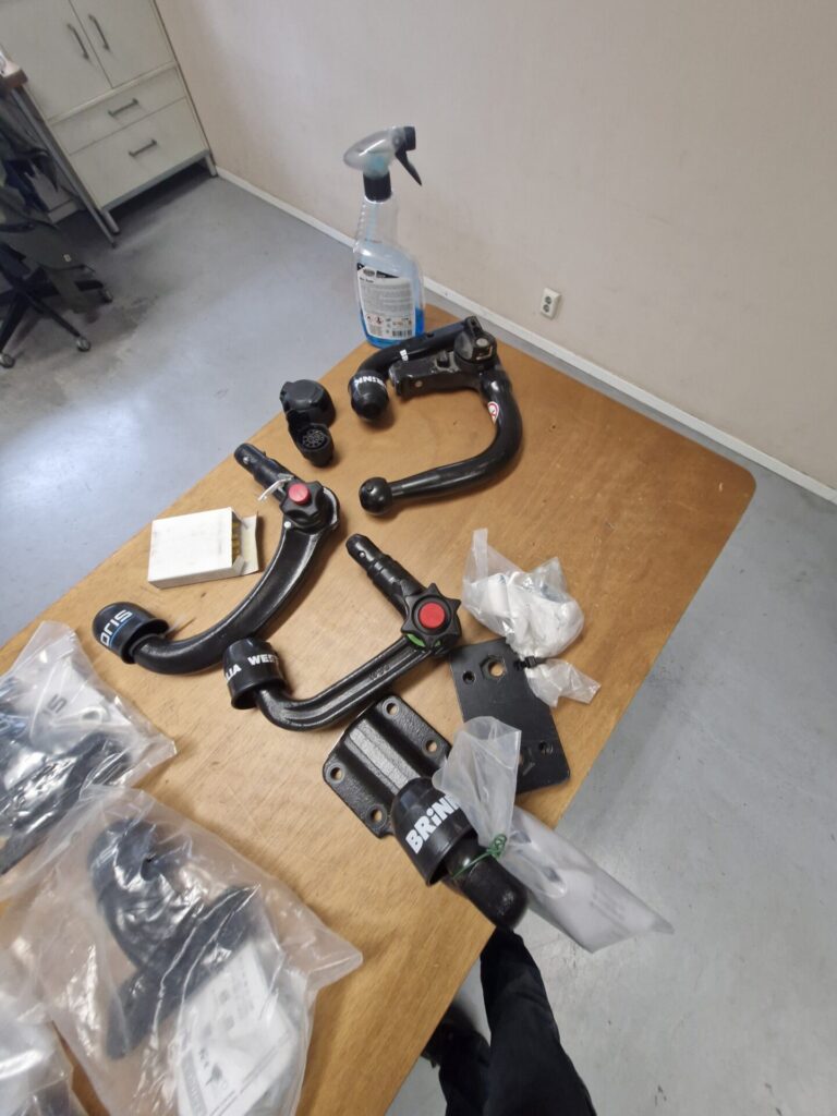 Trekhaakonderdelen en een sprayflacon op een houten tafel